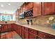 Well-lit kitchen with cherry cabinets, granite countertops, modern appliances, and a wine rack at 2592 Highmount Ct, Carmel, IN 46033