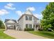 Two-story home boasting a portico, stone accents, manicured lawn, and mature trees at 2898 Violet W Ct, Columbus, IN 47201