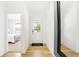 Bright entryway with wood floors and white walls, view of bedroom, and black framed mirror at 3152 Glasgow Pl, Danville, IN 46122