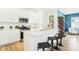 Modern kitchen island features bar seating, stainless appliances, white cabinets, and views of the front living area at 3152 Glasgow Pl, Danville, IN 46122