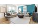 Bright living room with blue accent wall, neutral sofas, a modern coffee table, and large windows at 3152 Glasgow Pl, Danville, IN 46122