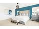 Well-lit bedroom with upholstered bed, blue accent wall and unique chandelier lighting at 3152 Glasgow Pl, Danville, IN 46122
