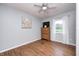 Bedroom with vinyl flooring, a ceiling fan, a dresser, and a window with white curtains at 318 S Routiers Ave, Indianapolis, IN 46219