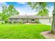 Charming ranch-style home with a well-manicured lawn and inviting curb appeal, set against a backdrop of mature trees at 318 S Routiers Ave, Indianapolis, IN 46219