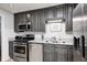 Close up of modern kitchen design with stainless steel appliances and dark cabinets at 318 S Routiers Ave, Indianapolis, IN 46219