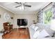 Cozy living room with wood floors, a gray sofa, a ceiling fan and large window providing natural light at 318 S Routiers Ave, Indianapolis, IN 46219
