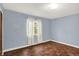 Bedroom featuring blue walls, hardwood floors, and a window at 3215 E Edgewood Ave, Indianapolis, IN 46227