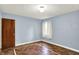 Bedroom featuring blue walls, hardwood floors, and a window at 3215 E Edgewood Ave, Indianapolis, IN 46227