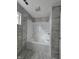 Bathroom featuring new gray marble look tiling and a shower-tub combo at 3305 E 30Th St, Indianapolis, IN 46218