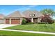 Charming brick home featuring a manicured lawn, a two-car garage, and lush landscaping at 3335 Guilford Ln, Plainfield, IN 46168