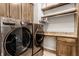 Organized laundry room with front-load washer and dryer, custom cabinets, granite countertop, and shelving at 3335 Guilford Ln, Plainfield, IN 46168