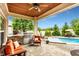 Relaxing outdoor space featuring a kitchen, seating, ceiling fan, pool, and lush landscaping at 3335 Guilford Ln, Plainfield, IN 46168