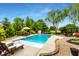 Backyard inground pool surrounded by beautiful landscaping, deck chairs, and a shaded table set at 3335 Guilford Ln, Plainfield, IN 46168