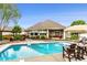 A lovely backyard pool is surrounded by chairs, a table with an umbrella, and professional landscaping at 3335 Guilford Ln, Plainfield, IN 46168