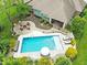 Aerial image of a beautiful backyard featuring a pool, patio with fire pit, and lush landscaping at 3335 Guilford Ln, Plainfield, IN 46168
