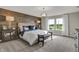 Bright bedroom featuring wood accent wall, stylish lighting, neutral carpet and abundant natural light from large windows at 3449 Glasgow Pl, Danville, IN 46122