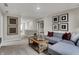 A carpeted loft with a large sectional and window, accented by a wooden coffee table and wall art at 3449 Glasgow Pl, Danville, IN 46122