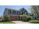 Lovely two-story home featuring a mix of siding and brick, a neat lawn, and an attached brown garage at 409 Spring Green Pl, Indianapolis, IN 46229