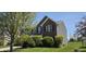 A two-story home with a combination of siding and brick, a well-kept lawn, and green bushes at 409 Spring Green Pl, Indianapolis, IN 46229