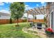 Inviting backyard featuring a pergola, mature tree, and manicured lawn at 442 Mozart Dr, Greenfield, IN 46140