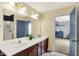 Bathroom featuring double sinks, dark wood cabinets, tile floors, shower, and primary bedroom access at 442 Mozart Dr, Greenfield, IN 46140