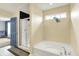 Bathroom featuring a soaking tub, a shower with a glass door, and a window at 442 Mozart Dr, Greenfield, IN 46140