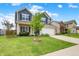 Two-story home featuring blue siding, brick accents, manicured lawn, and a young tree at 442 Mozart Dr, Greenfield, IN 46140