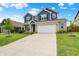 Charming two-story home featuring blue siding, brick accents, manicured lawn, and an attached two-car garage at 442 Mozart Dr, Greenfield, IN 46140
