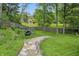 Picturesque backyard features a charming stone pathway and mature trees with a tire swing at 4614 Thornleigh Dr, Indianapolis, IN 46226
