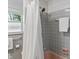 Bathroom featuring gray tile, a salmon tub, and a silver shower head, complemented by a window with greenery view at 4614 Thornleigh Dr, Indianapolis, IN 46226