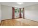 An empty bedroom with hardwood floors, light gray walls, and a window with pink curtains at 4614 Thornleigh Dr, Indianapolis, IN 46226