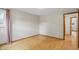 An empty bedroom featuring hardwood floors, light gray walls, and a window with pink curtains at 4614 Thornleigh Dr, Indianapolis, IN 46226