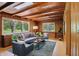 Cozy wood-paneled living room with beamed ceiling and large windows at 4614 Thornleigh Dr, Indianapolis, IN 46226