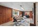 Cozy living room boasts wood-paneled walls, stylish furniture, and natural light streaming through large windows at 4614 Thornleigh Dr, Indianapolis, IN 46226