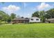 The backyard features a brick facade, white siding, a sunroom, a patio, and a large grassy area at 4614 Thornleigh Dr, Indianapolis, IN 46226