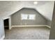 This spacious attic bedroom has light gray walls, carpet, and a double-hung window for natural light at 4814 E New York St, Indianapolis, IN 46201