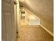 Attic hallway with a banister, neutral carpet, light gray walls, and access to the other rooms at 4814 E New York St, Indianapolis, IN 46201