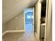 The attic bedroom with access to the full bathroom featuring gray walls, carpet, and attic ceiling at 4814 E New York St, Indianapolis, IN 46201