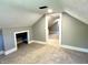 View of the attic bedroom featuring neutral carpet, gray walls, access to closet, and entrance to the next room at 4814 E New York St, Indianapolis, IN 46201