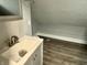 The bathroom featuring vinyl floors, angled ceilings, gray walls, and a single sink vanity at 4814 E New York St, Indianapolis, IN 46201