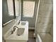 Bathroom with a double sink vanity, marble-look shower walls, window with blinds, and gray paint at 4814 E New York St, Indianapolis, IN 46201