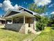 Inviting single-story home with a covered front porch, stone detailing, and a well-manicured lawn at 4814 E New York St, Indianapolis, IN 46201