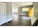 Inviting living room featuring wood floors, bright window, and a yellow door at 4814 E New York St, Indianapolis, IN 46201