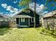 Back view of a cozy, dark-painted home with a fenced yard and manicured grass at 4814 E New York St, Indianapolis, IN 46201