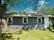 Rear view of a gray home featuring a white door, three windows, and a clean yard at 4814 E New York St, Indianapolis, IN 46201