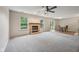 Spacious carpeted living room featuring a brick fireplace, ample natural light, and dining area access at 513 Sun Catcher Dr, Avon, IN 46123