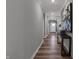 Long hallway with wood floors leads to the front door and features stylish decor and neutral paint at 5273 Nettleton Way, Avon, IN 46123