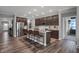 Open-concept kitchen with an island and seating, stainless steel appliances, and wood flooring at 5273 Nettleton Way, Avon, IN 46123