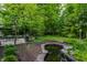 Lush backyard featuring a pond, stone edging, patio and lush green lawn at 5326 White Marsh Ln, Indianapolis, IN 46226