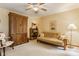 Cozy bedroom featuring a comfortable seating area, ceiling fan, and natural light from windows at 5326 White Marsh Ln, Indianapolis, IN 46226